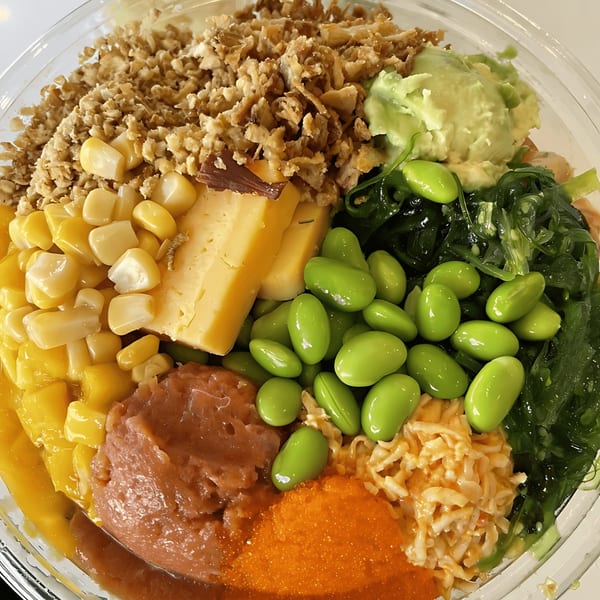 Close-up of a vibrant Rollrritto Poke Bar poke bowl with various colorful ingredients.